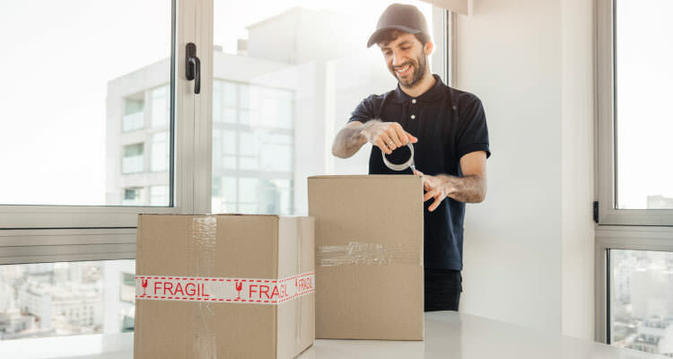 Guy packing fragile boxes