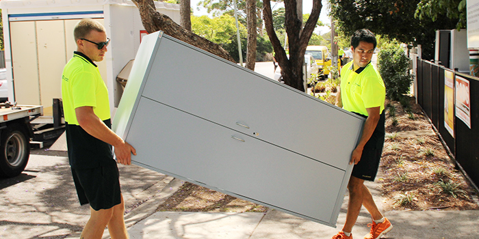 professional movers moving a cabinet